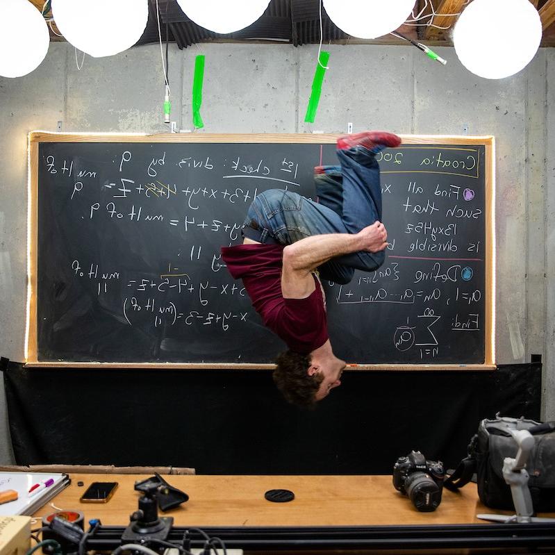 Randolph math professor Michael Penn throws in one of his signature backflips while recording a video for his popular YouTube channel.